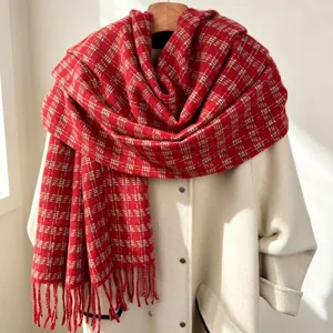 Red plaid winter scarf detail, soft tassel fringe, warm cozy fabric for cold weather.