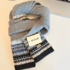 Nordic style knitted winter scarf detail view, cozy grey wool material with classic geometric patterns.