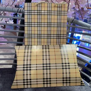 Dettaglio confezione regalo a quadri classica con sacchetto di carta e scatola.