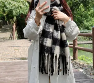 Cozy black and white plaid mohair scarf with fringe detail, perfect for cold winter days.