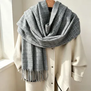 Cozy gray plaid scarf with elegant tassels, perfect warm winter accessory for women.