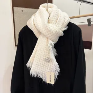 Cozy cream knit scarf with textured waffle pattern and frayed fringe edges for winter style