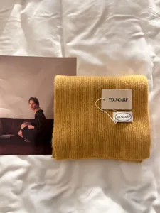 Detailed view of a soft yellow knitted scarf, featuring cozy thick texture and chic style.