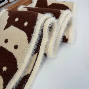 Vista dettagliata della sciarpa in maglia con motivo di gatto e finitura in peluche, inverno.