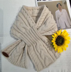 Dettaglio sciarpa incrociata in maglia crema, caldo collo invernale in misto lana morbido.