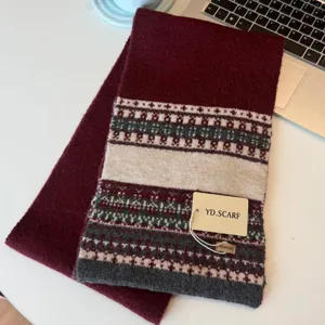 Detail view of a cozy Nordic style knitted scarf featuring warm burgundy patterns.