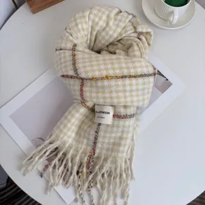 Detailed shot of beige plaid winter scarf with tassels, soft warm fabric texture display