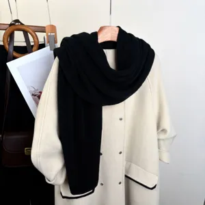 Dettaglio di una sciarpa in maglia nera, consistenza morbida, accessorio invernale.