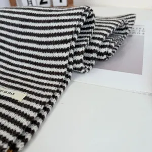 Black and white striped knitted scarf detail shot, cozy autumn winter warm neck wrap chic.