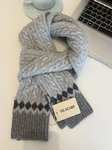 Cozy grey cable knit winter scarf with stylish diamond pattern and soft texture.