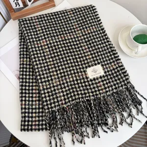 Classic black and white houndstooth scarf with cozy tassels, warm winter fashion accessory.