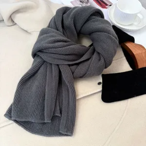 Primo piano della sciarpa in maglia grigio scuro, consistenza morbida, accessorio invernale.