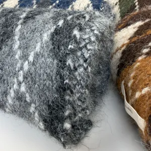 Close-up detail shot of fluffy mohair check winter scarf showing soft fuzzy texture and weave.