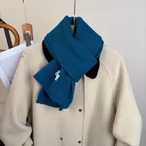 Vista dettagliata della sciarpa in maglia blu accogliente su cappotto beige, effetto lana.