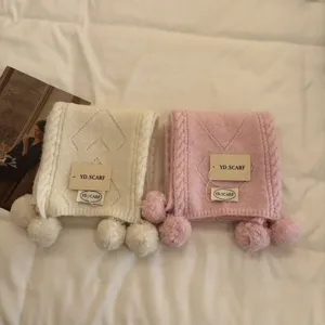 Cozy knitted pompom scarf in soft pastel colors, stylish winter neck warmer for women.