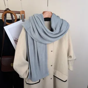 Dettaglio sciarpa in morbida maglia, elegante scaldacollo grigio invernale, comodo accessorio moda.