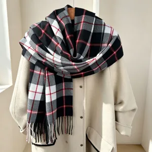 Dettaglio sciarpa a quadri con frange, morbido cashmere finto, nero bianco rosso, inverno.