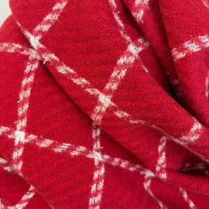 Close-up view of red and white plaid winter scarf fabric featuring subtle metallic sparkle threads.