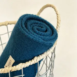 Solid color knitted winter scarf rolled in a basket, warm and cozy Korean style fashion accessory.