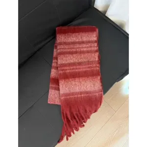 Detailed view of the cozy wide-striped mohair winter scarf with fringe in warm tones.
