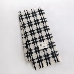 Close-up detail of black and white grid winter warm scarf, soft texture, cozy accessory.