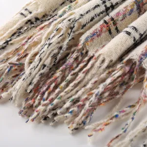 Close up view of women winter warm plaid scarf with colorful fringe details soft knitted fabric.