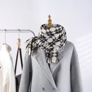 Detailed view of the black and white grid winter scarf showing texture, cozy fabric and fringe.