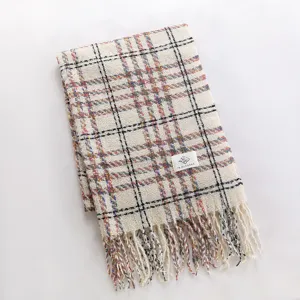 Winter cozy colorful plaid scarf with chic tassels, soft warm fabric, detailed texture close-up.