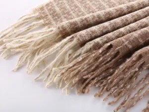 Close-up of cozy women's plaid tassel scarf detail, soft imitation cashmere fabric.