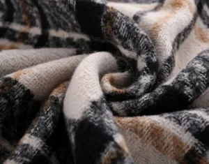 Close-up detail shot showing soft plaid winter scarf fabric texture and warm feel.