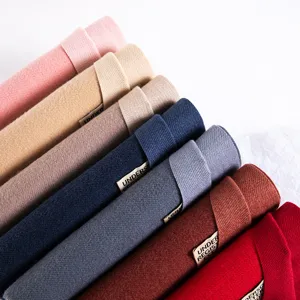 Close-up detail of thickened imitation cashmere scarves rolled neatly in various solid colors.