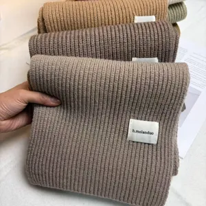 Detailansicht eines dicken Strickschals in warmen Erdtönen, kuschelige Winteraccessoires.