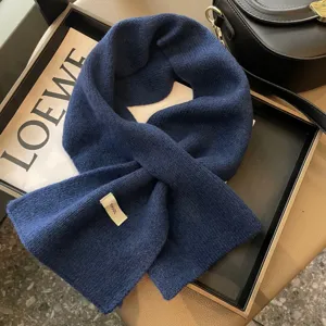 Vista dettagliata sciarpa incrociata invernale a tinta unita da donna foulard di lana blu.