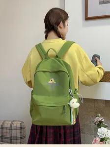 Detailed view of the stylish green canvas school backpack featuring a cute cartoon dog print.