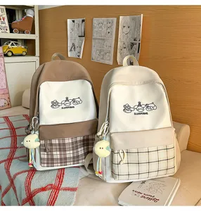 Japanese style canvas school backpack with plaid pocket and cute hanging pendant for students.