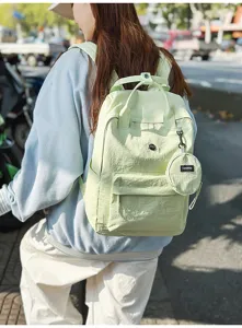 Detailansicht eines hellgrünen Freizeit-Rucksacks mit kleiner runder Münztasche und Fronttasche.