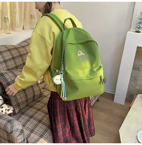 Detailed view of casual green backpack for students with cute puppy print and pendant decor
