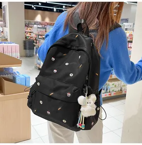 Korean casual collegiate style black backpack for women with cute embroidery and fluffy plush pendant.