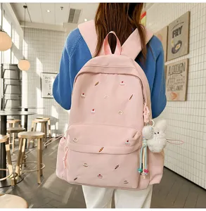 College style pink embroidered backpack for women, casual school bookbag with cute plush pendant.