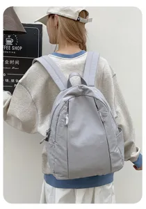 Detail view of the minimalist nylon backpack worn by model, showcasing casual daily style.