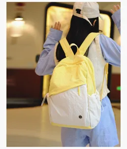 Primo piano di dettaglio lifestyle dello zaino casual giallo e bianco indossato sulla schiena.