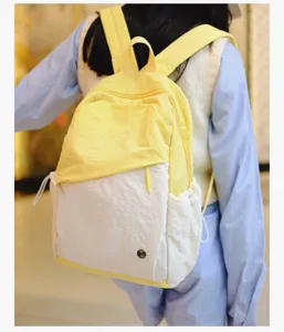 Vista dettagliata di un elegante zaino casual in tela giallo e bianco per l'uso quotidiano.