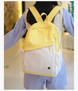 Vista dettagliata dello zaino bicolore casual indossato, con tasca con zip e comode tasche laterali.