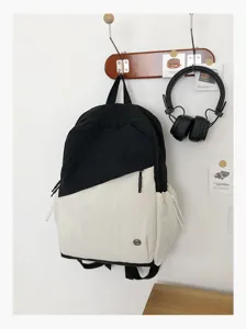 Dettaglio dello zaino minimalista bicolore bianco e nero con tasca frontale con cerniera e laterali.