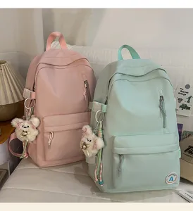 Casual candy color school backpack detail view with cute plush bear keychain charm.