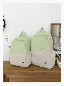 Vista dettagliata degli zaini scolastici bicolore casual in verde chiaro e beige.