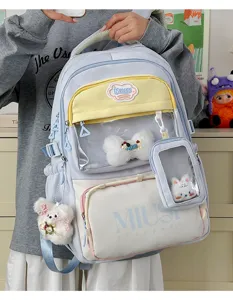 Detailed view of Japanese style student backpack with clear front pocket and cute plush pendants.