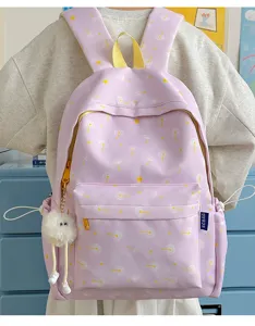 Detail view of sweet light purple backpack with dandelion print, cute plush pendant, and yellow accents.