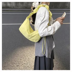Detailed view of casual yellow nylon pleated shoulder bag, stylish commuter dumpling bag.