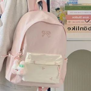 Japanese ins style pink backpack for women, cute bow embroidery school bag with plush pendant.